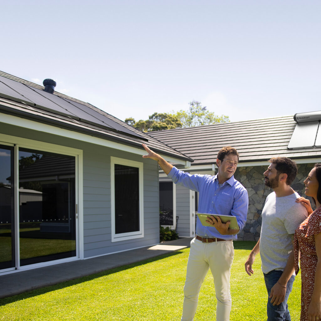 close up of man from solahart dealership assessing a home and explaining to the home owners