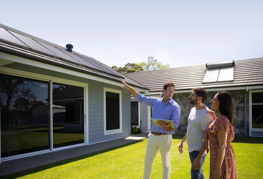 close up of man from solahart dealership assessing a home and explaining to the home owners